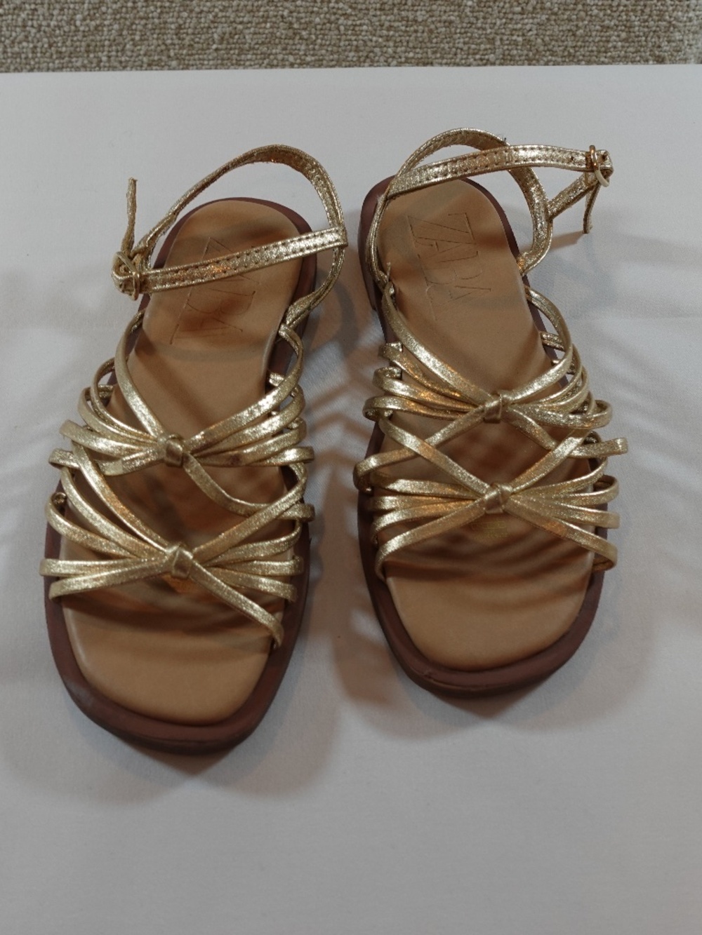 SANDALS WITH GOLD COLORED STRAPS AND KNOTTED